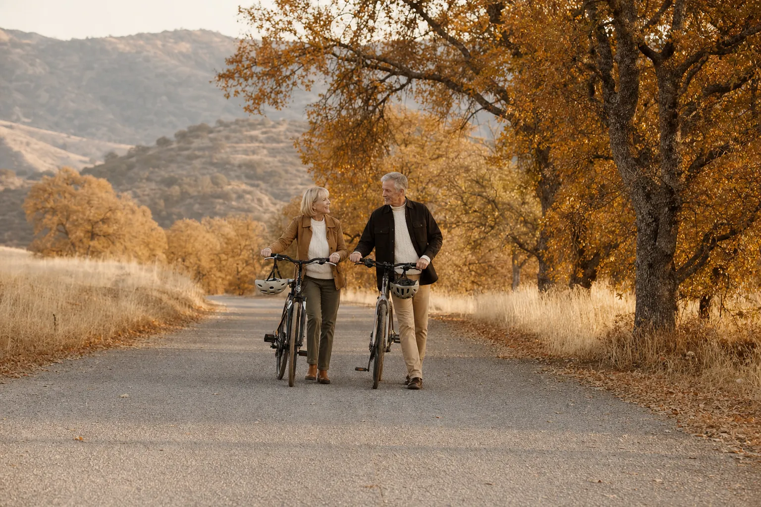 A couple walking their bicycles together on a country lane.