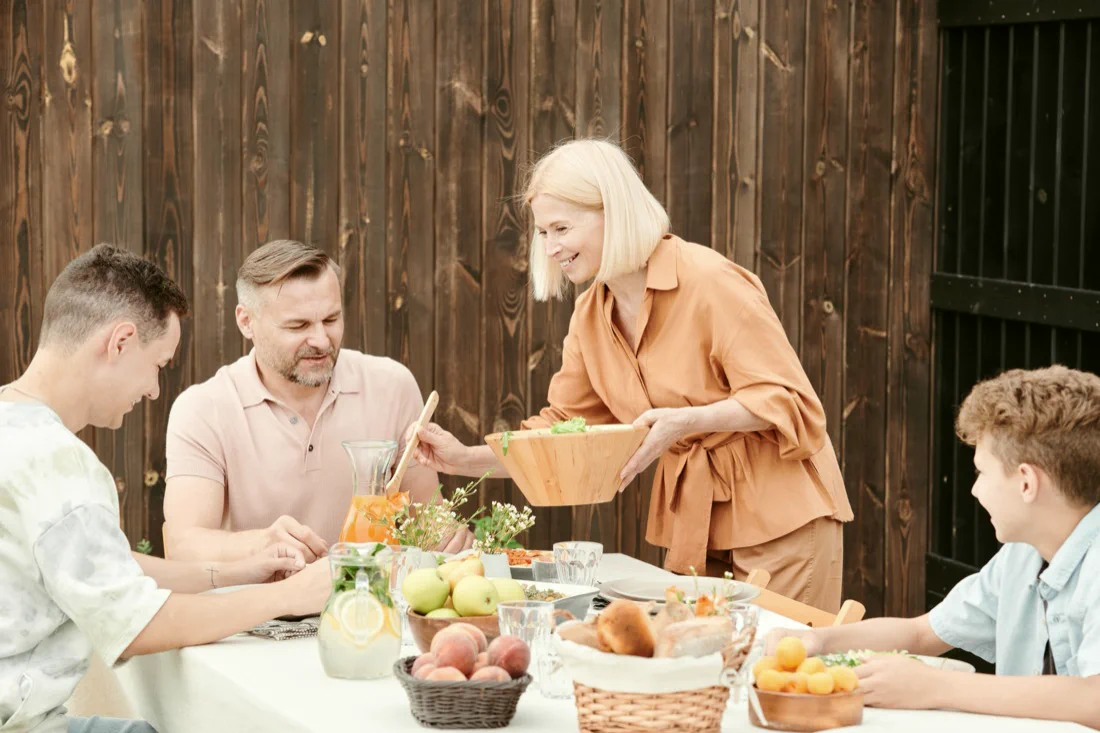 A family gathered around the table, sharing a relaxed lunch.